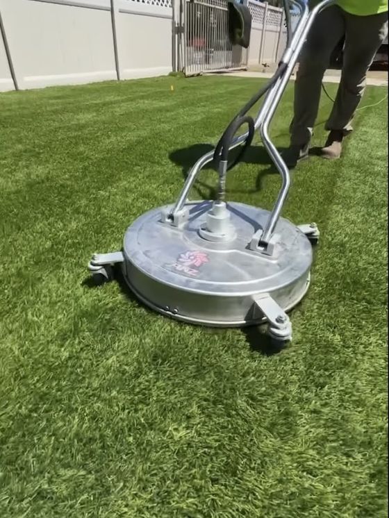 A rotary surface cleaner being run across artificial turf