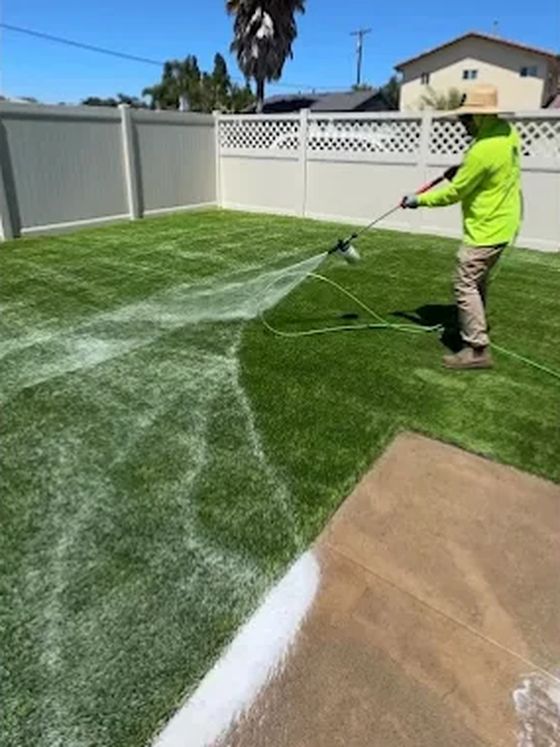 Jake rinsing down a turf lawn during a clean